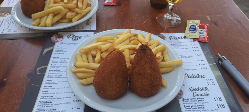 Piatto di arancini e patatine fritte che abbiao mangiato in trattoria a Tindari, Messina