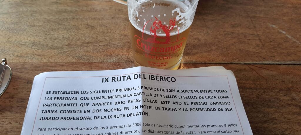 Birra e foglio illustrativo dell'evento Ruta del Iberico a Tarifa, in Spagna.